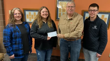 AAACU Team member presents a check to a member of the Cheboygan High School Senior Class of 2025